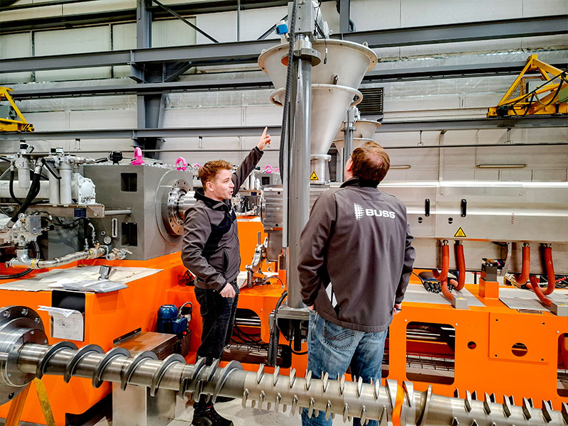 buss_team_kollegen-inspizieren-compeo-cis Zwei Kollegen aus dem BUSS Team inspizieren eine COMPEO CIS Inlet Screw im Rahmen der Qualitätsprüfung, um BUSS' Anspruch zu wahren.