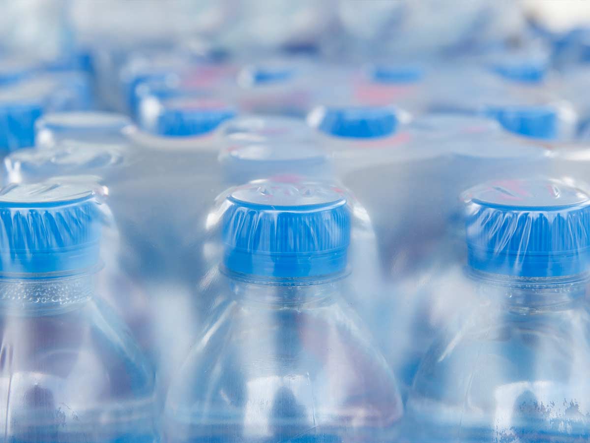 Viele Wasserflaschen mit blauen Verschlusskappen.