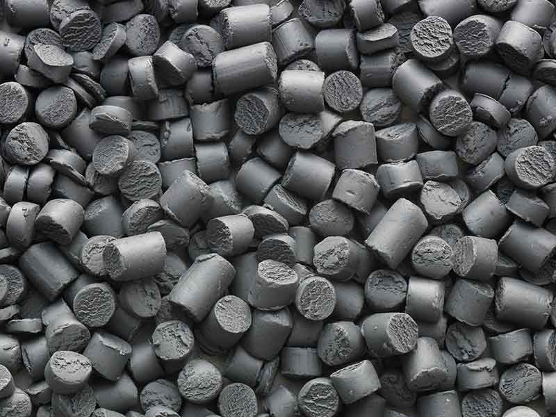 Mediante la tecnología de preparación de compuestos se fabrican trozos de masa en bruto de poliamida de color gris oscuro.